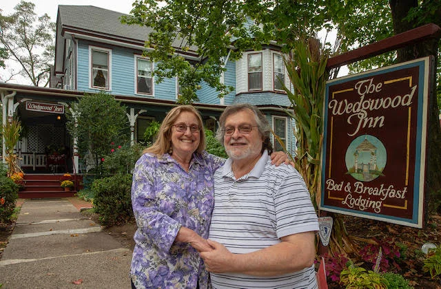Man_and_Woman_Inn_Owners_Standing_In_Front_WedgwoodInn_Sign
