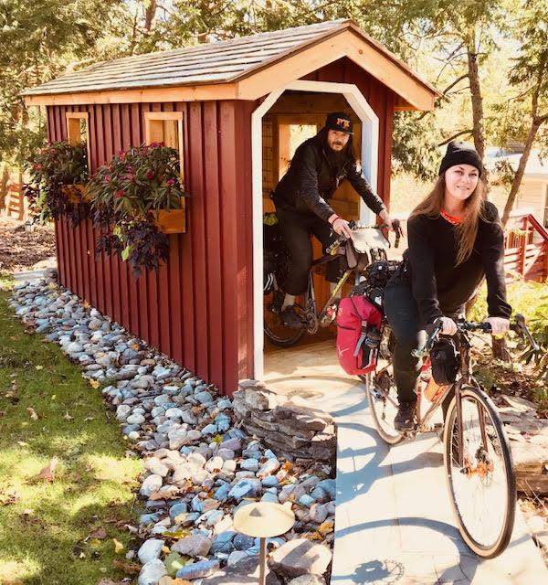 Man-Woman-biking-through-small-covered-wood-bridge-Wedgwood-backyard